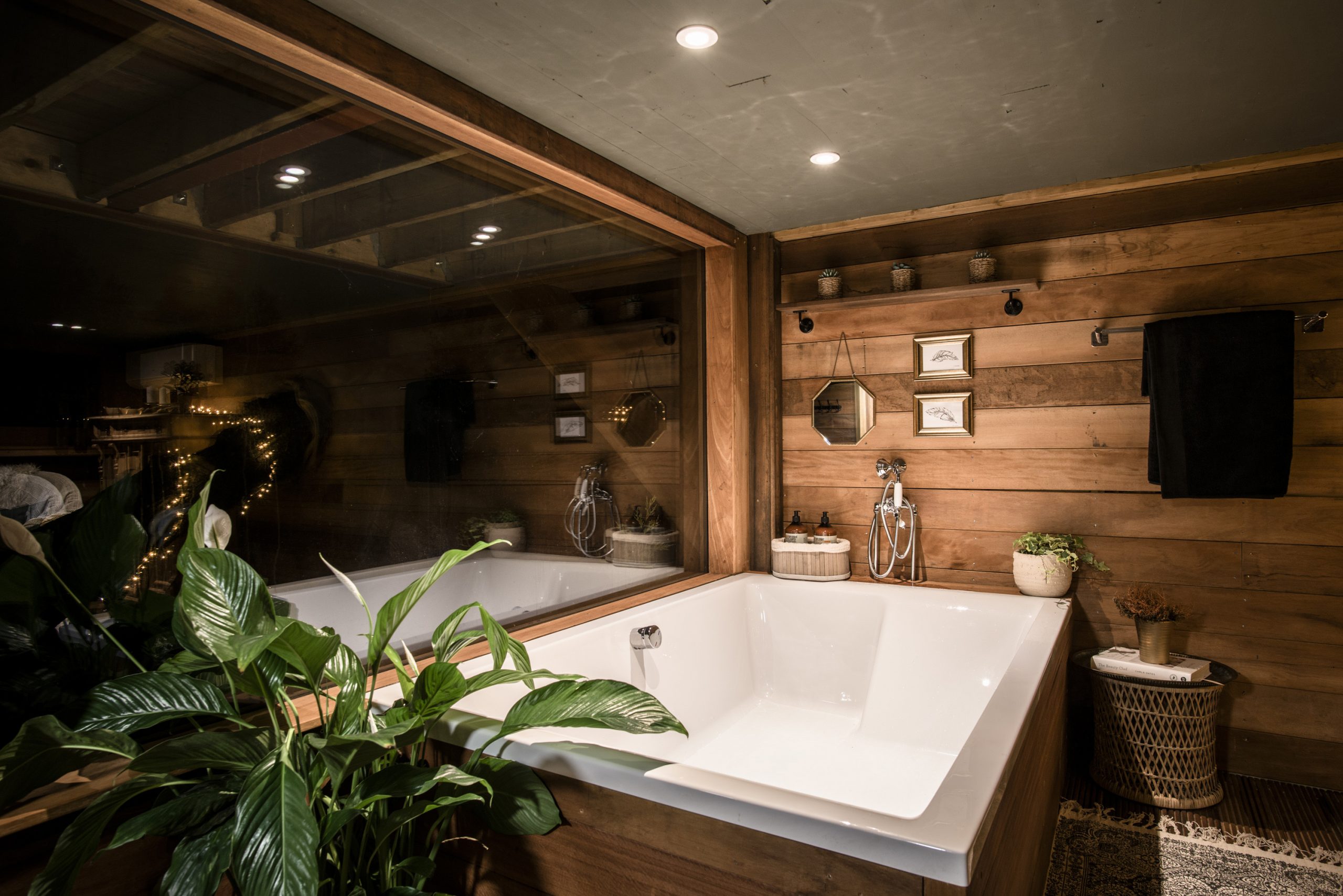 Nighttime photos showing the double bath and panoramic window in The Old Oak at Colemans Farm