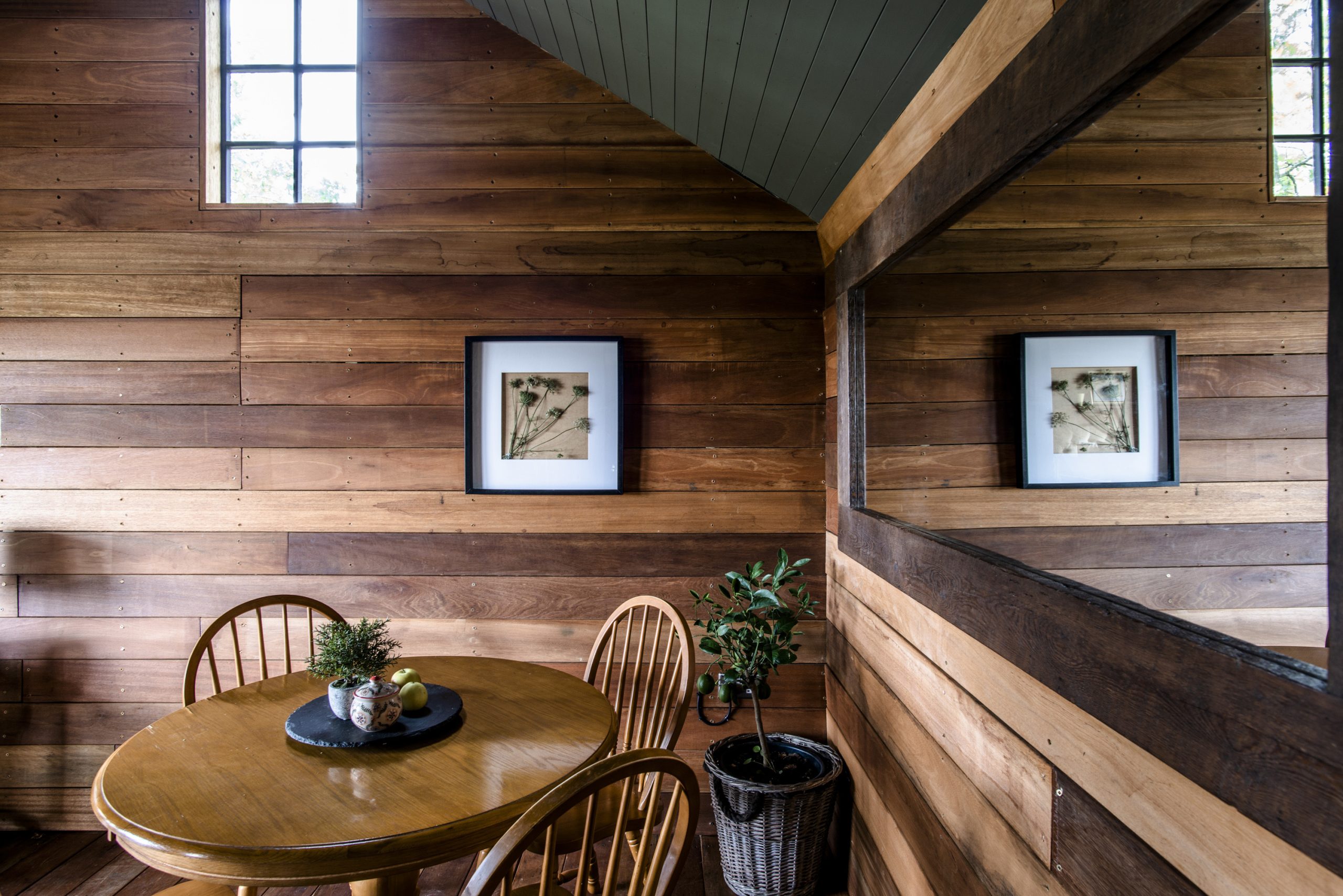 Dining area with large panoramic mirror and cedar cladded wall